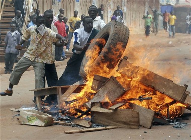 Rioters burn tyres and wood in the capital city Kampala, Uganda, Friday, April 29, 2011 after riots broke out. Army troops and police faced off against rioting demonstrators in downtown Kampala on Friday, the first time the Uganda's growing protest movement had reached the country's capital, and Red Cross officials said at least one person was killed and 64 wounded. (AP Photo / Stephen Wandera)